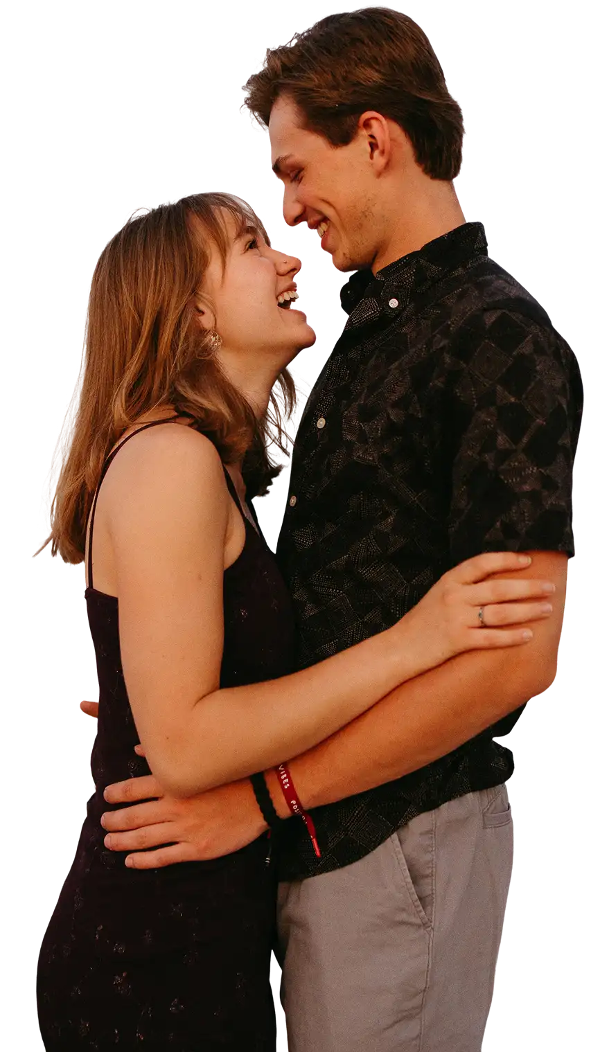 A happy couple embraces and looks at each other, laughing.