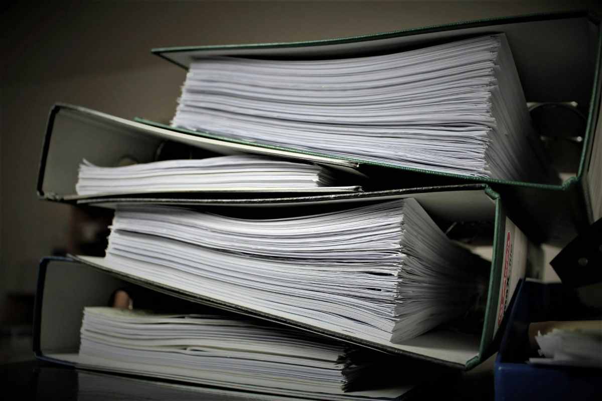 Stack of binders filled with paperwork, representing therapy intake forms to complete before the first sessio
