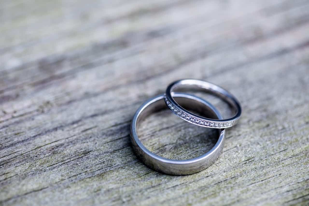 Two wedding rings on wooden surface symbolizing marriage commitment and counseling